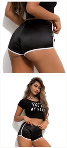 Detail of black sporty two-piece set featuring crop top and white-trimmed shorts
