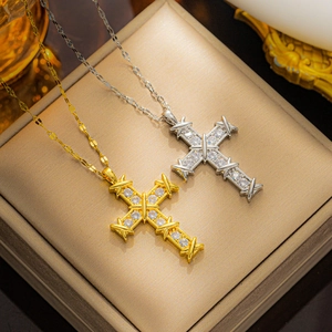Elegant gold and silver cross necklaces with micro-pave zircons in a jewelry box