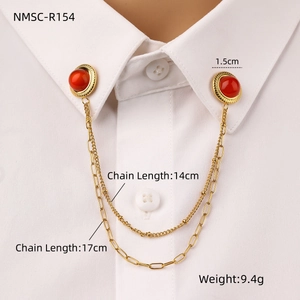 Detail view of gold stainless steel collar pin chain with red stones on a white shirt