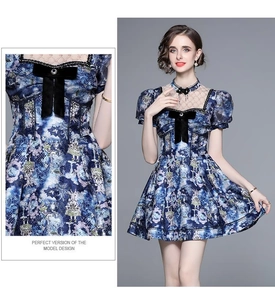 Detail of blue printed dress with puff sleeves, velvet bow, and mesh paneling