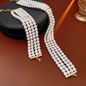 Détail d'un bracelet de perles à quatre rangs avec fermoir doré sur boîte à bijoux