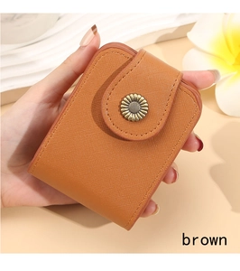 Close-up of brown Saffiano leather mini wallet with a vintage daisy metal snap button