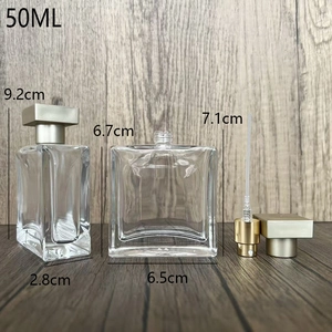 Square 50ml glass perfume spray bottle with gold pump and clear body on wood surface