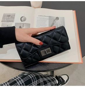 Close-up of a black quilted leather clutch with a vintage metal twist-lock fastener