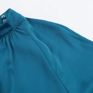 Détail de la robe midi en satin bleu sarcelle avec col montant et doubles boutons
