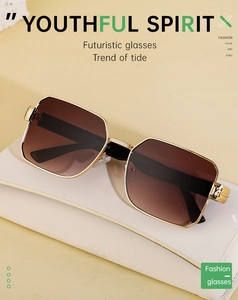 Detail of gold metal square frame sunglasses with brown gradient lenses on white leather
