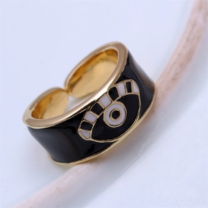 Macro shot of wide gold-plated devil's eye ring with black and white drip oil enamel