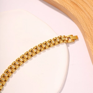 Detail eines vergoldeten Armbands im Uhrenstil mit funkelnden weißen Kristallen