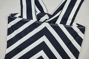 Close-up of V-neck neckline with blue and white stripes and crossed strap detail