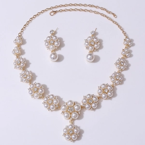 Detailed close-up of golden bridal jewelry set with white pearls and small crystals