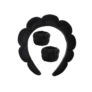 Close-up of black fuzzy twisted headband and matching wrist washbands set for women