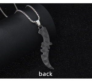 Macro detail of scythe pendant back featuring geometric 3D cube texture and steel chain