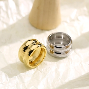 Detailed macro view of wide double-layered 18K gold and silver rings with mirror finish