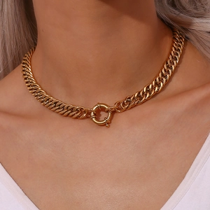 Close-up of golden chunky chain necklace with a large round spring clasp on a model