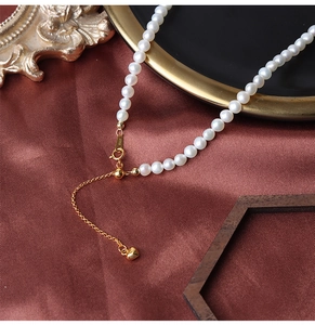 Detail of S925 sterling silver heart charm and adjustable clasp on pearl necklace