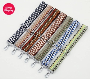 Detailed close-up of woven ethnic bag straps with silver metal hooks and adjusters