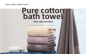 Close-up of four thick cotton bath towels with absorbent loop texture and gold stripes