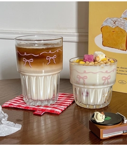 Detail of cartoon bow glass cup with coffee, yogurt and cereal in a lifestyle setting