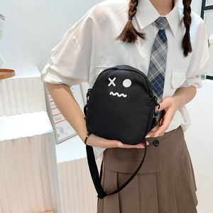 Étudiante portant un joli sac bandoulière en toile noire avec visage cartoon style JK