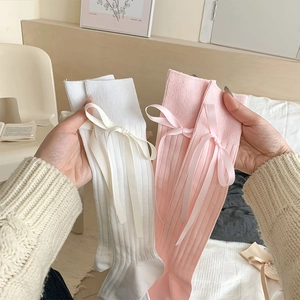 Detail of knit calf socks with vertical stripes and delicate ribbon bow decorations