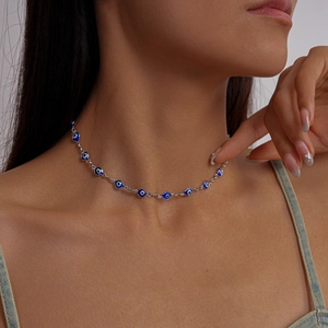 Detailed close-up of a three-piece Evil Eye necklace with blue glass beads on silver chain
