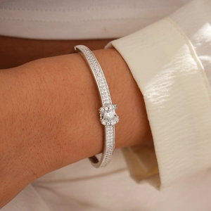 Macro shot of silver paved zircon bracelet with central round cut stone on a wrist