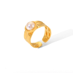 Macro detail of gold-plated hammered stainless steel ring with white round pearl
