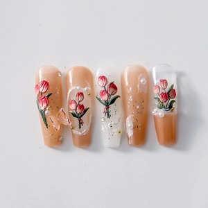 Nude pink press-on nails featuring 3D embossed red tulips, pearls, and resin butterflies