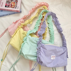 Detail showing candy-colored pleated drawstring bags in pink, yellow, green, and purple