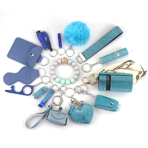 Blue multi-tool outdoor self-defense keychain set with alarm and pompom on white background