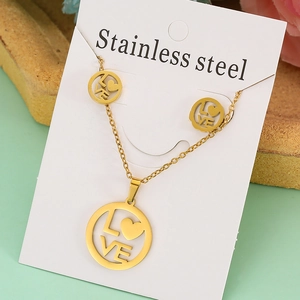 Detail of gold stainless steel jewelry set with circular LOVE and heart pendants