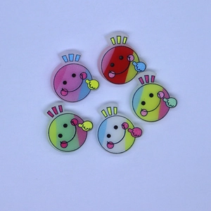 Detail view of five colorful smiley face acrylic charms for DIY phone cases and hair accessories