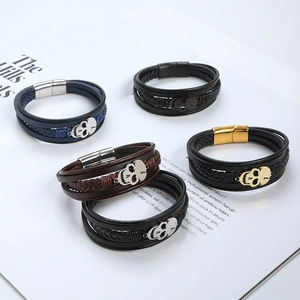 Five styles of woven leather skull bracelets with magnetic clasps on an open book