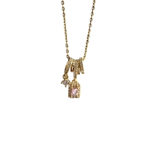 Collier doré à pampilles avec cristal rose rectangulaire et zircons sur fond blanc