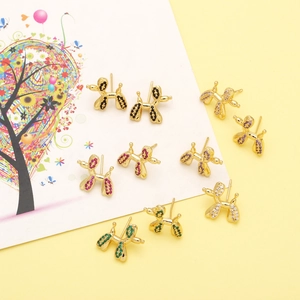 Detail of colorful balloon dog earrings with vibrant zircon stones on a creative background