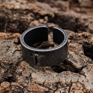 Vintage oxidized silver biker ring for men with cutout cross pattern on rustic bark
