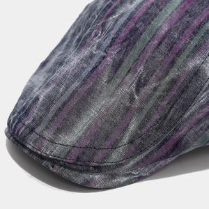 Detail of colorful striped beret showing woven cotton texture and reinforced brim stitching