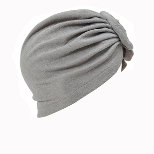 Grey textured turban hat with layered pleated design and side knot detail for fashion