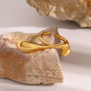 Detailed view of gold 18k plated stainless steel water drop ring on natural stone