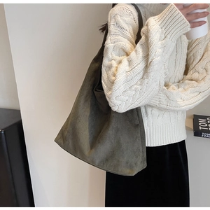 Detail of soft olive green faux suede tote bag shown on model with cozy knit sweater