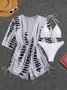 Three-piece bikini set with white halter top and black-white abstract print cover-up