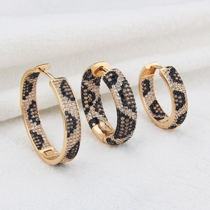 Three-piece leopard print pavé zircon gold-plated hoop earrings on white fabric