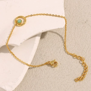 Detail of 18K gold-plated stainless steel bracelet with light green gemstone and lobster clasp