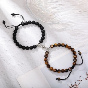 Macro detail of tiger eye stone beads and magnetic heart clasp on braided couple bracelets