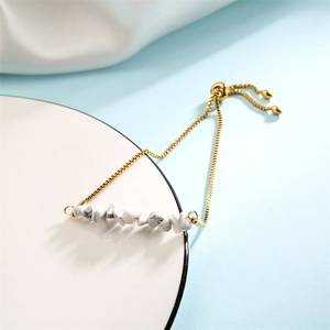 Detail of adjustable gold stainless steel bracelet with white marble stone and slider clasp