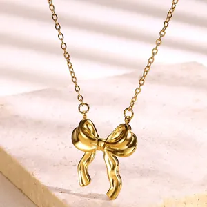 Detailed view of polished 18k gold bow pendant with elegant ribbon texture on stone