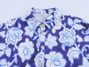 Détail du col d'une chemise à imprimé floral avec boutons en bois et fleurs mauves