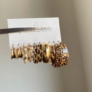 Macro detail of acrylic pearl and leopard print hoop earring set on display card