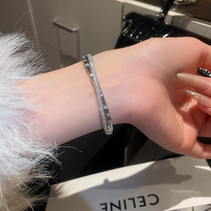Macro shot of double-row cross design bangle with micro-set cubic zirconia stones