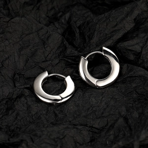 Polished silver hoop earrings with a minimalist round design on a dark textured background